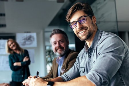 Vier Mitarbeitende in einer Besprechung im Büro.