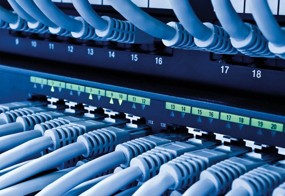 Detailaufnahme eines Netzwerks bzw. Netzwerk-Hubs mit vielen Kabeln.