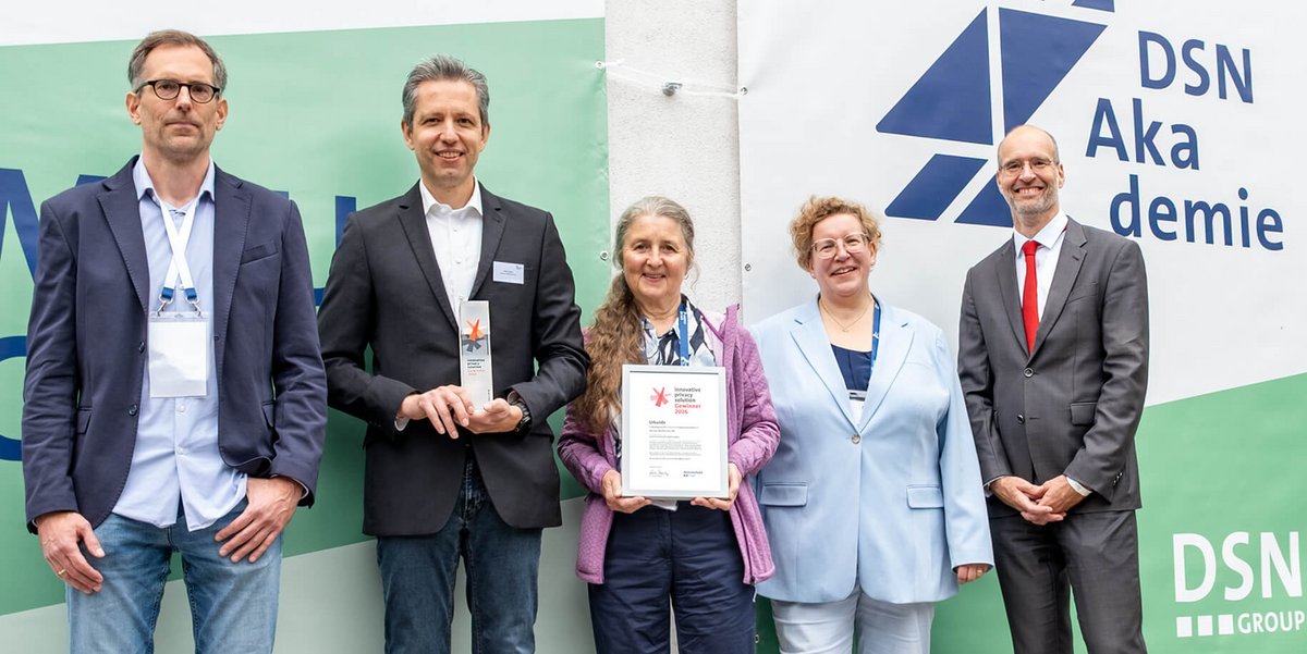 Foto der Übergabe des ips-Preises 2026 durch die datenschutz cert an zwei Mitarbeitende des Gewinnerunternehmens.