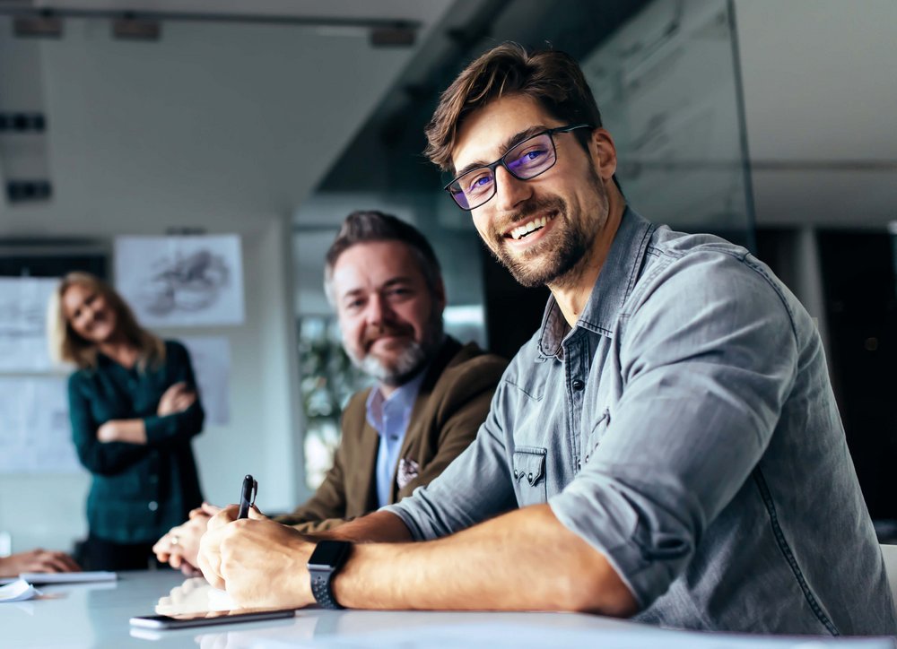 Vier Mitarbeitende in einer Besprechung im Büro.