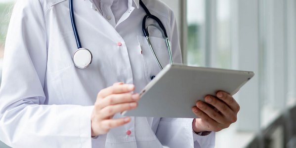 Ärztin mit Tablet und Stethoskop.