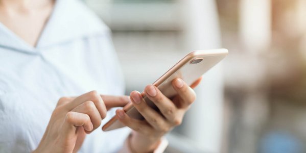 Nahaufnahme von einer Frau, die ein Handy in der Hand hält
