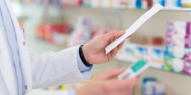 Ein Apotheker mit einem Rezept in der Hand.