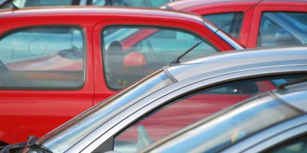 Parkplatz wo drei Autos geparkt sind.