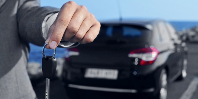 Ein Mann der einen Autoschlüssel in der Hand hält.