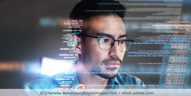 Junger konzentrierter Mann programmiert, Codezeilen im Hologrammstil.