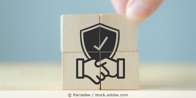 Vier Holzkötzchen, die zusammen ein Bild ergeben mit Schutzschild und Händeschütteln-Symbol.