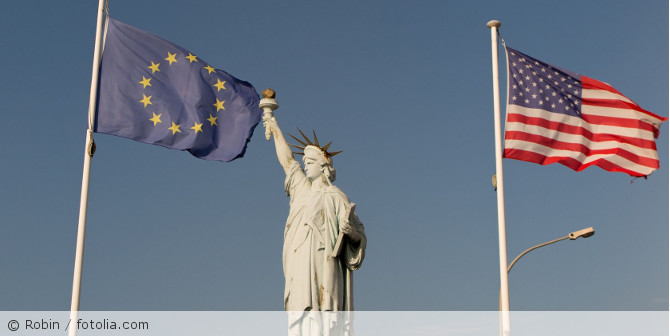Die Freiheitsstatur mit einer USA und einer EU Flagge.