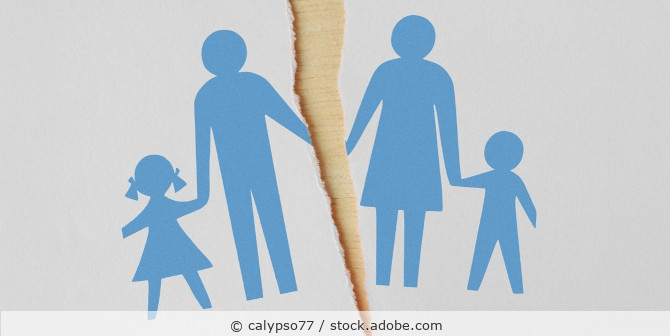 Umrisse einer vierköpfigen Familie aus Papier, in der Mitte ist ein Riss.