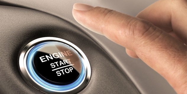 Person drückt auf den Start Knopf um das Auto zu starten.