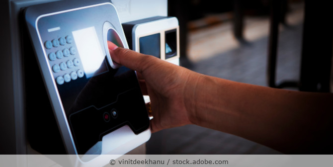 Mann scannt seinen Fingerabdruck am Eingang zur biometrischen Authentifizierung.