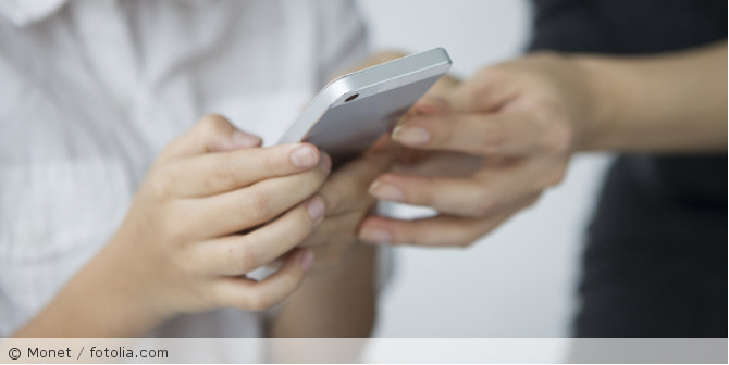 Hände die ein Handy in der Hand halten.