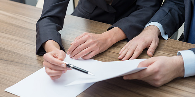 Personen mit einem Stift und Zettel in der Hand.