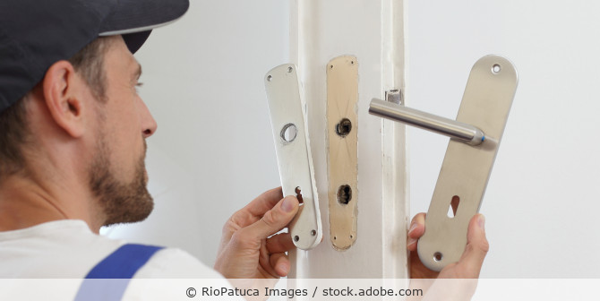 Handwerker wechselt Türgriff
