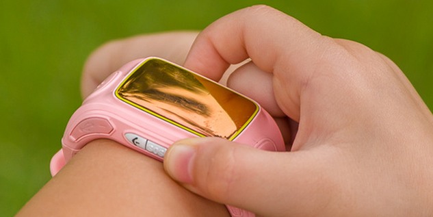 Ein kleines Mädchen hat eine pinke Kindersmartwatch.