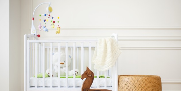 Ein Gitterbett mit Kindersachen.