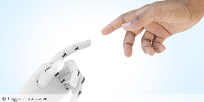 Ein Mensch und ein Roboter strecken sich die Hand zu.