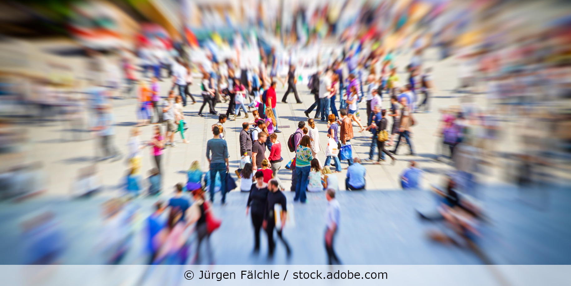 Viele Menschen laufen über einen Platz in der Stadt.