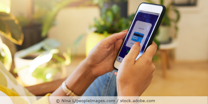 Smartphone in den Händen einer Frau mit Onlinezahlungsfunktion auf dem Bildschirm