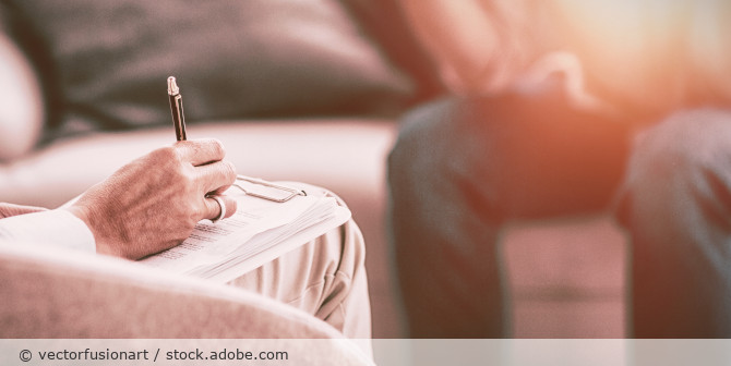 Person mit Stift und Fragebogen in der Hand.