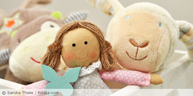 Eine Puppe mit Kuscheltieren.
