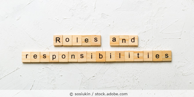 Holzbuchstabenkärtchen aus denen Roles and Resopnsibilities gelegt ist