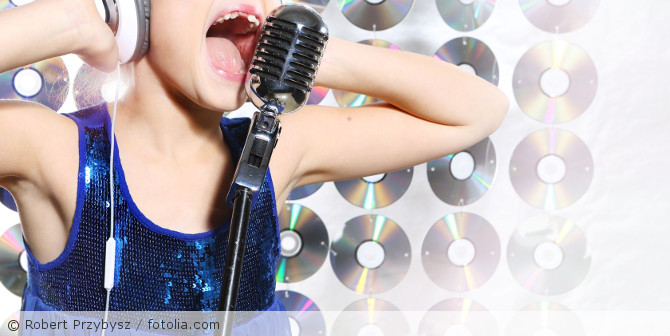 Ein Kind das in ein Mikrofon singt.
