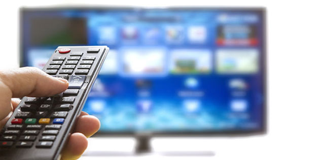 Mann mit einer Fernbedienung sucht was im Fernseher.