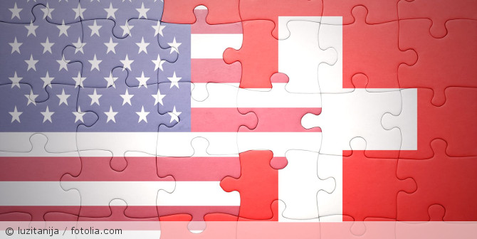 Ein Puzzle mit den Flaggen der USA und der Schweiz.