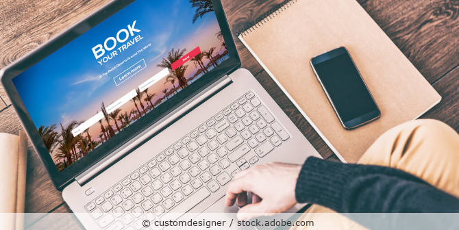 Person bucht Urlaub per Laptop.