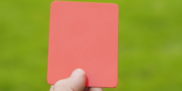 Eine Hand die eine rote Karte hält.